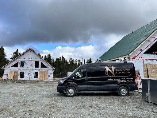 Une camionnette noire est garée devant un immeuble en construction.