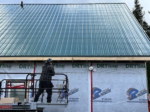 Un homme se tient debout sur un ascenseur et travaille sur un toit en métal.