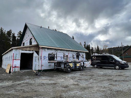 Une camionnette est garée devant un immeuble en construction.