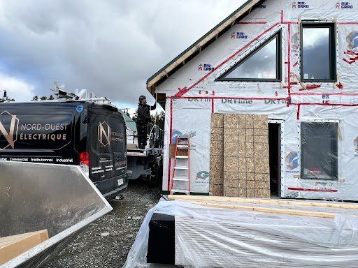 Un homme se tient debout sur un camion à côté d'un bâtiment en construction.