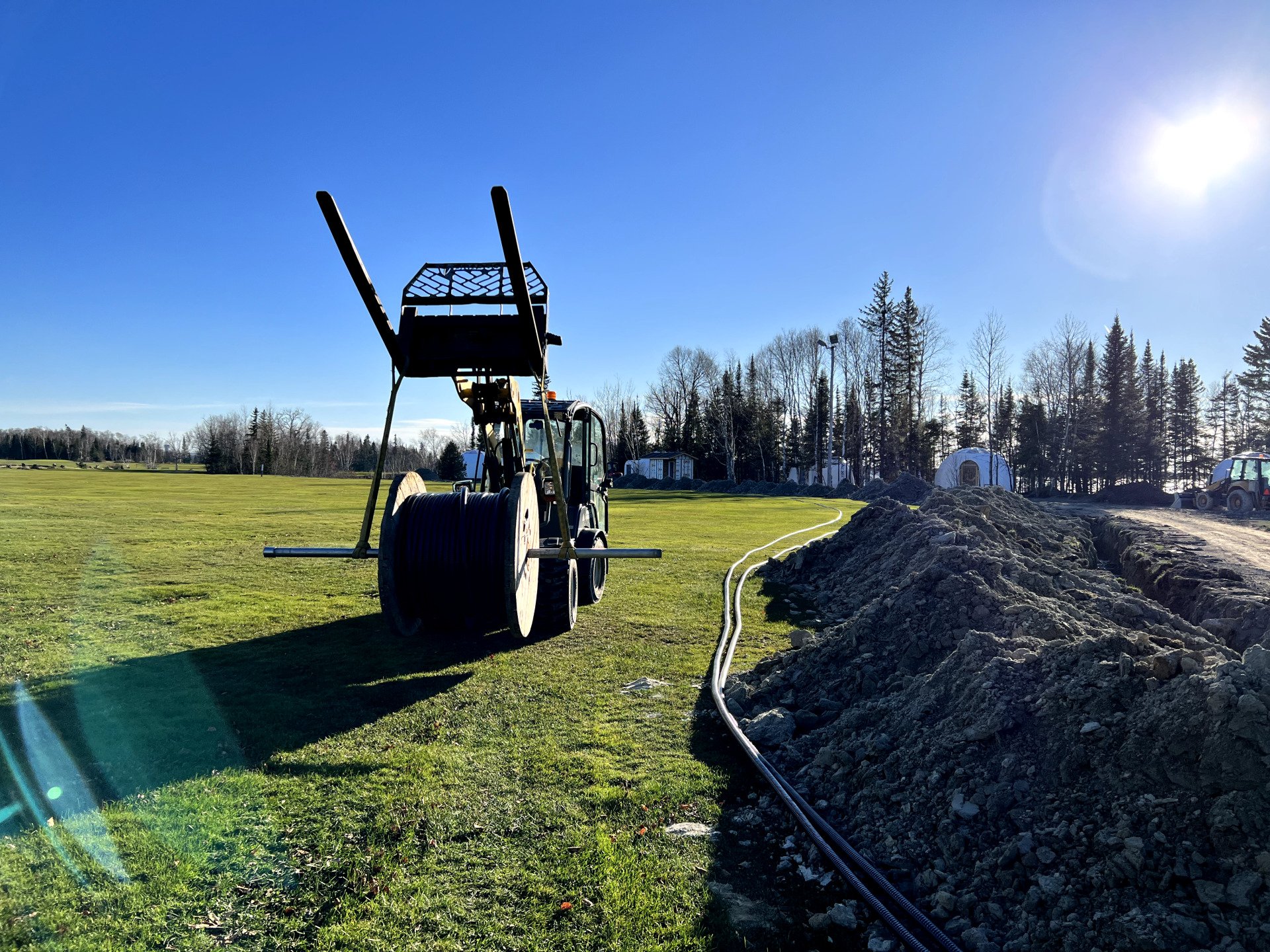 Un tracteur est dans un champ avec un tas de fils qui en sortent.