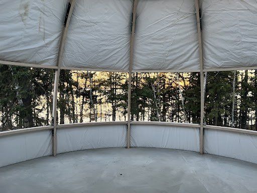 L'intérieur d'une tente avec vue sur les arbres à travers les fenêtres.