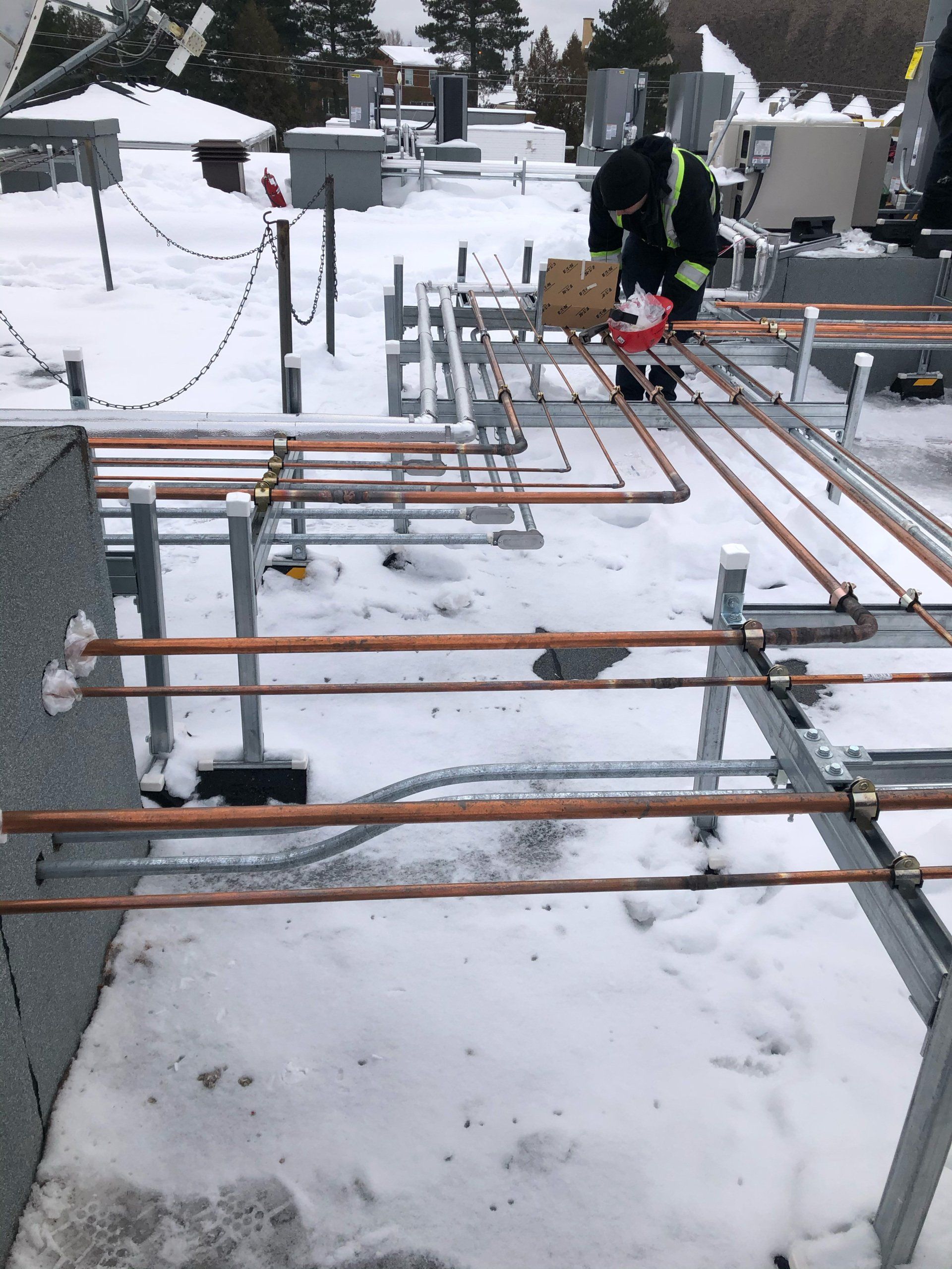 Un homme travaille sur un toit recouvert de neige