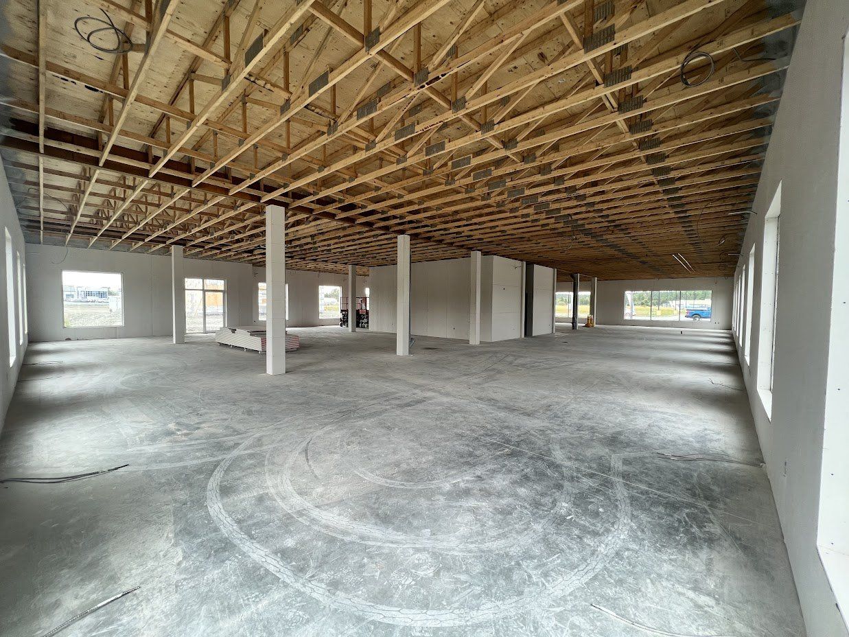 Une grande pièce vide avec un plafond en bois et beaucoup de fenêtres.