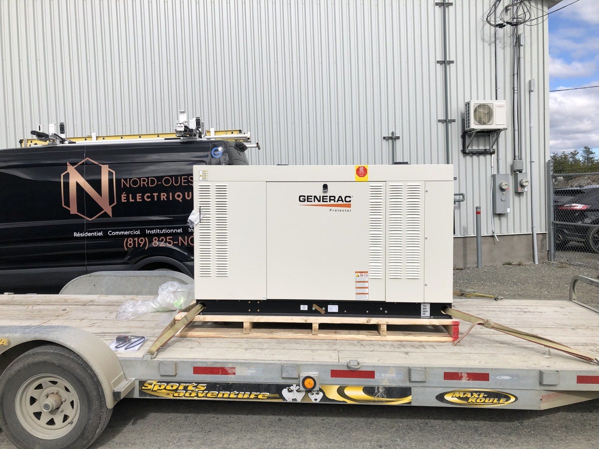 Un générateur est assis sur une remorque à côté d'une camionnette.