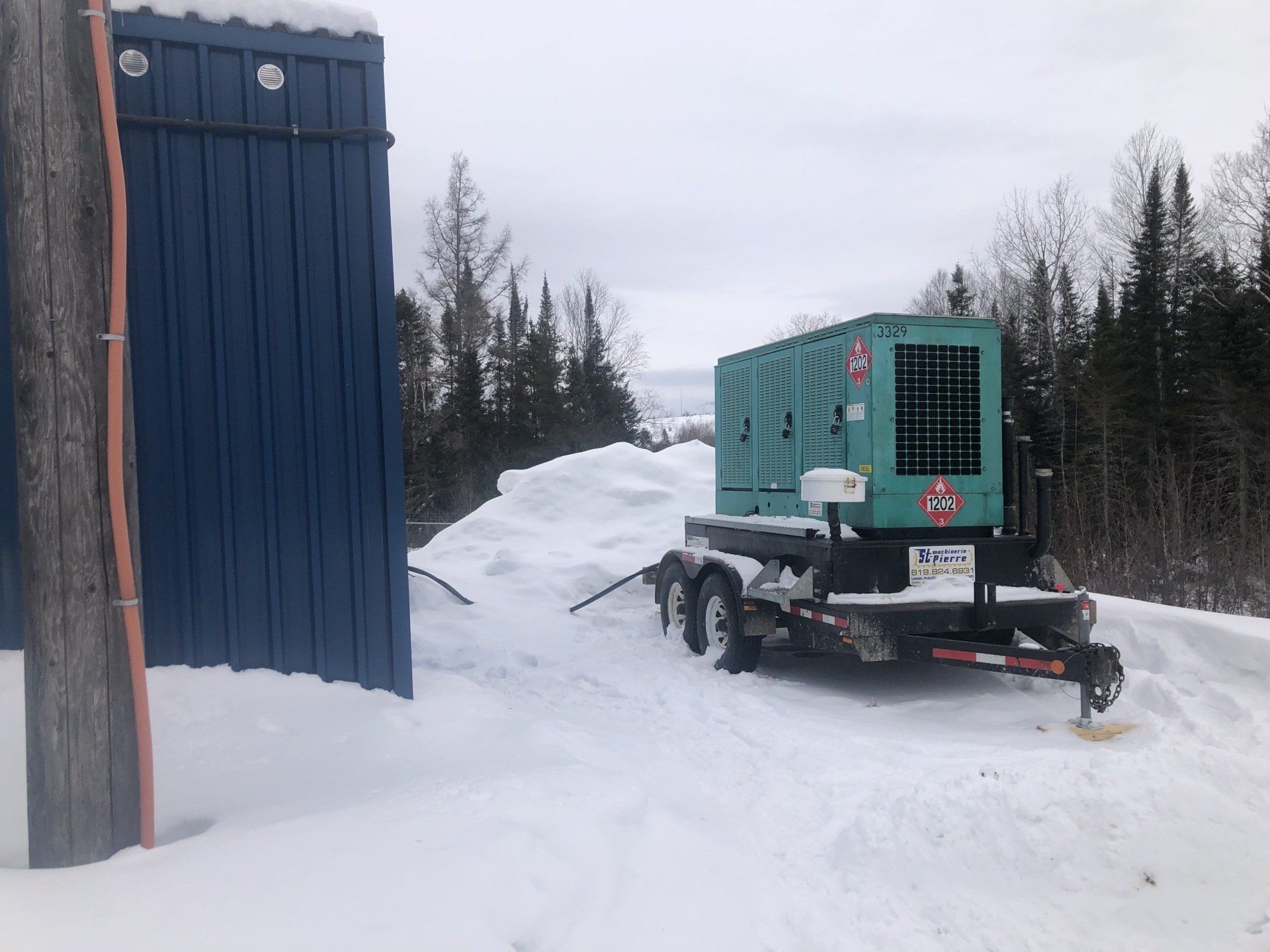 Une remorque avec un générateur dessus est garée dans la neige.