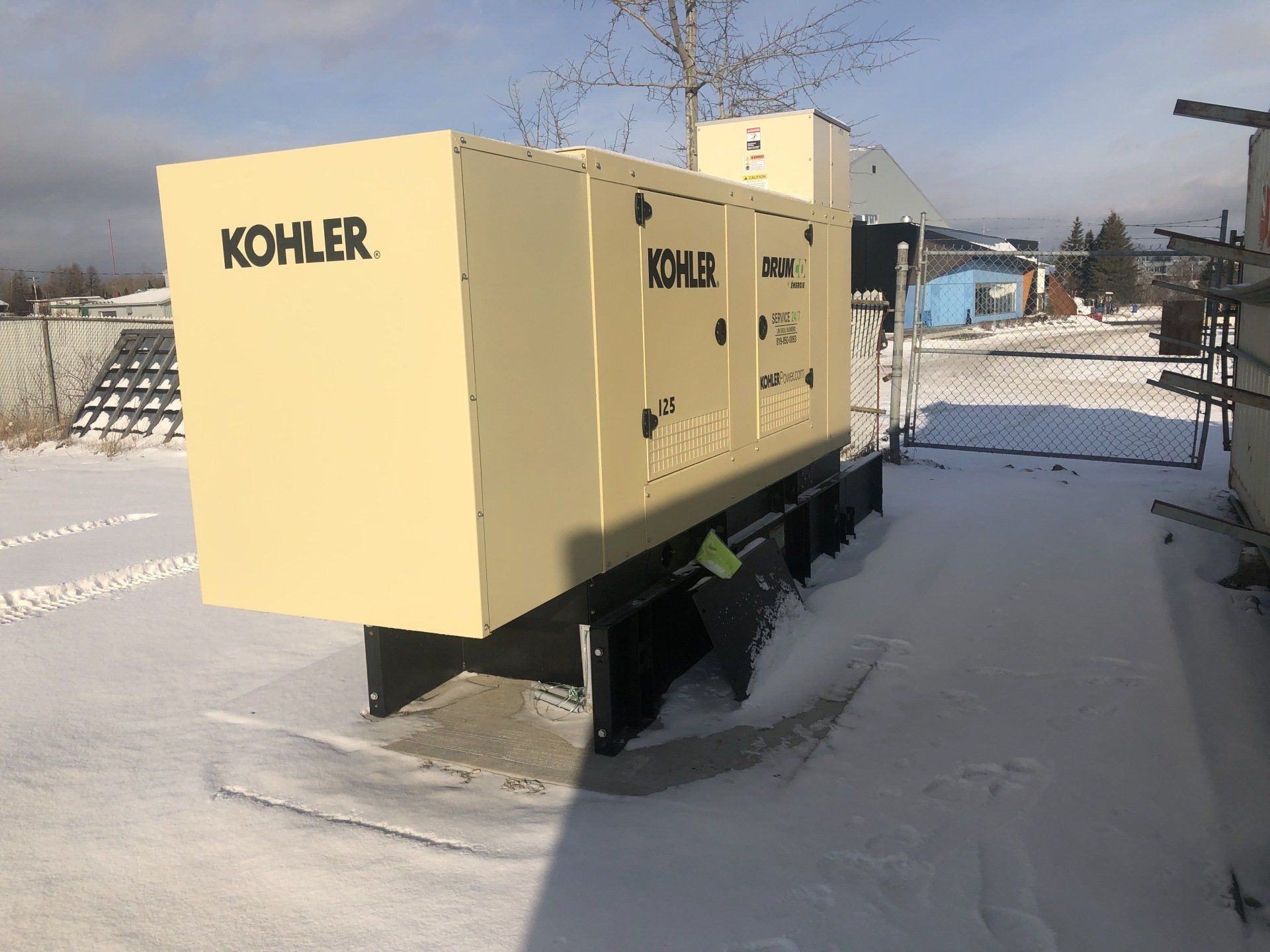 Un gros générateur Kohler est assis dans la neige.