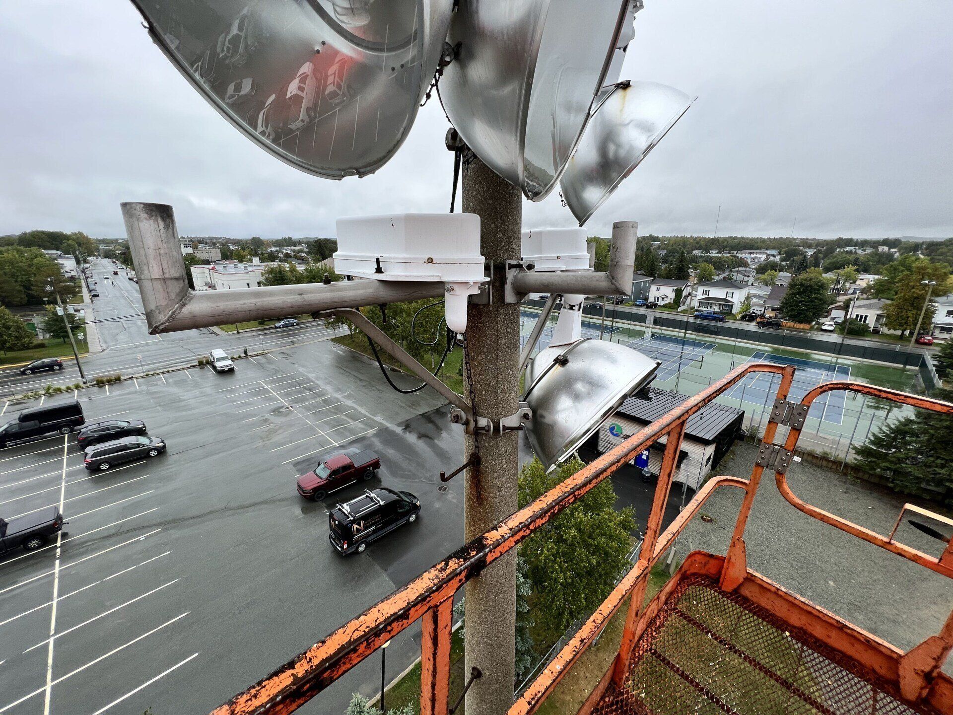 Un tas de lumières sont suspendues à un poteau dans un parking.