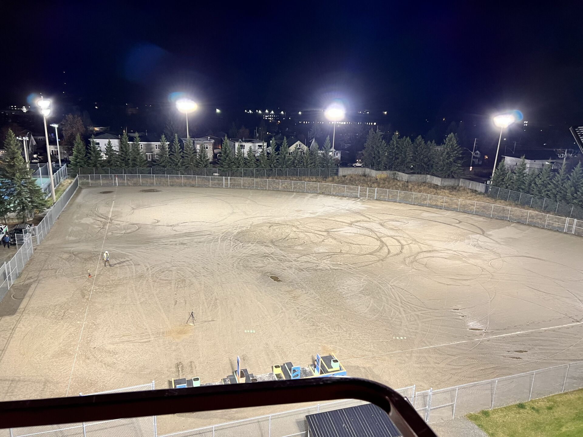 Un terrain de baseball vide est éclairé la nuit.