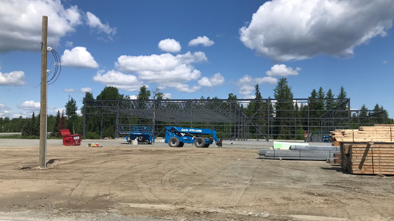 Un chantier avec un tracteur bleu au milieu.