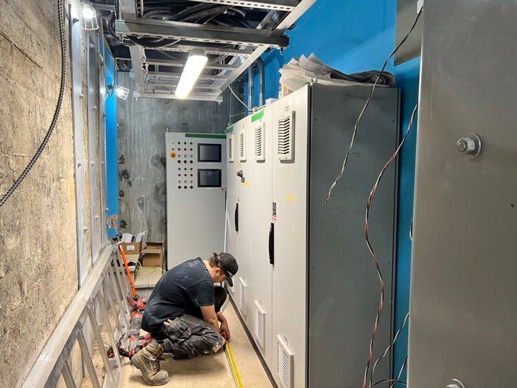 Un homme est agenouillé dans une pièce avec un ruban à mesurer.