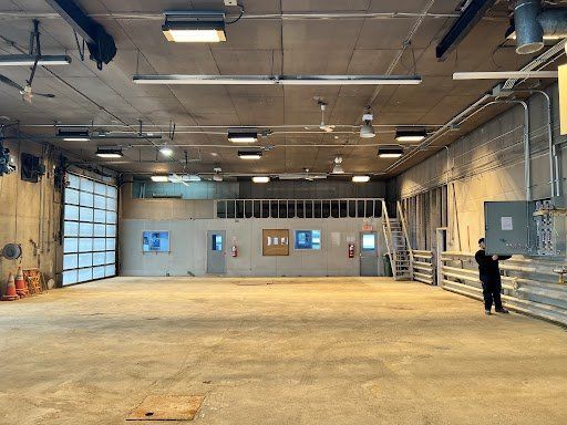 Un homme se tient debout dans un grand entrepôt vide.