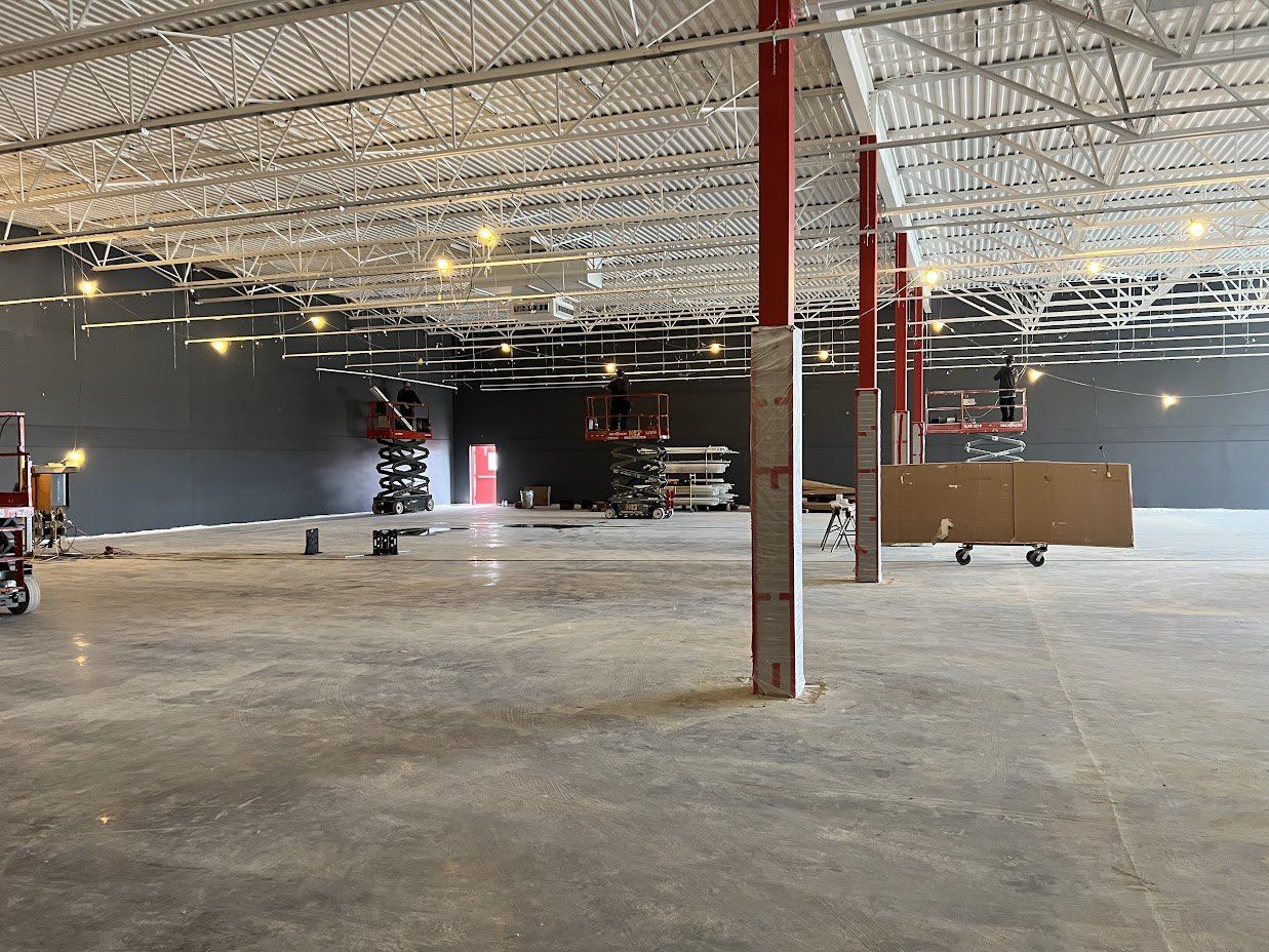 Un grand entrepôt vide avec un plafond en cours de construction.