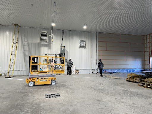 Un groupe de personnes se tient dans un grand entrepôt.