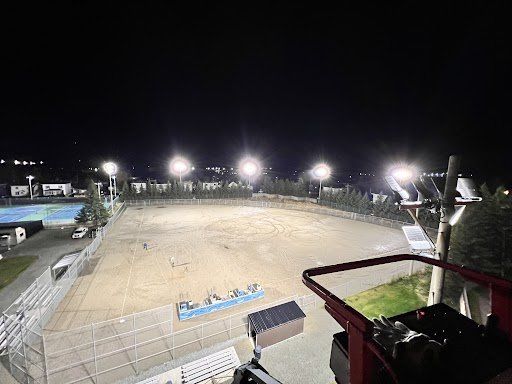 Un grand terrain de football vide est éclairé la nuit.