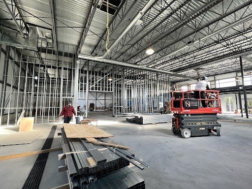 Un homme se tient debout dans un grand entrepôt en construction.