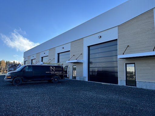 Une camionnette noire est garée devant un immeuble.