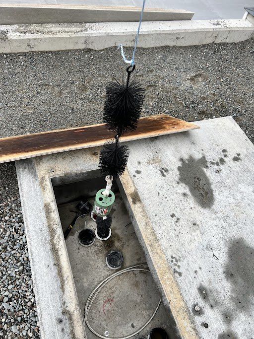 Une brosse est suspendue à un crochet au sommet d'une surface en béton.