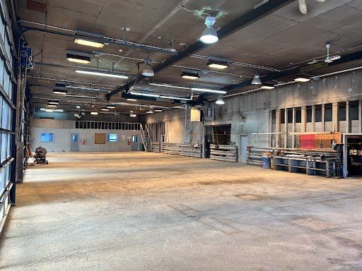 Un grand entrepôt vide avec beaucoup de lumières au plafond.