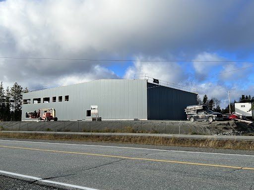 Un grand bâtiment est en construction à côté d'une autoroute.