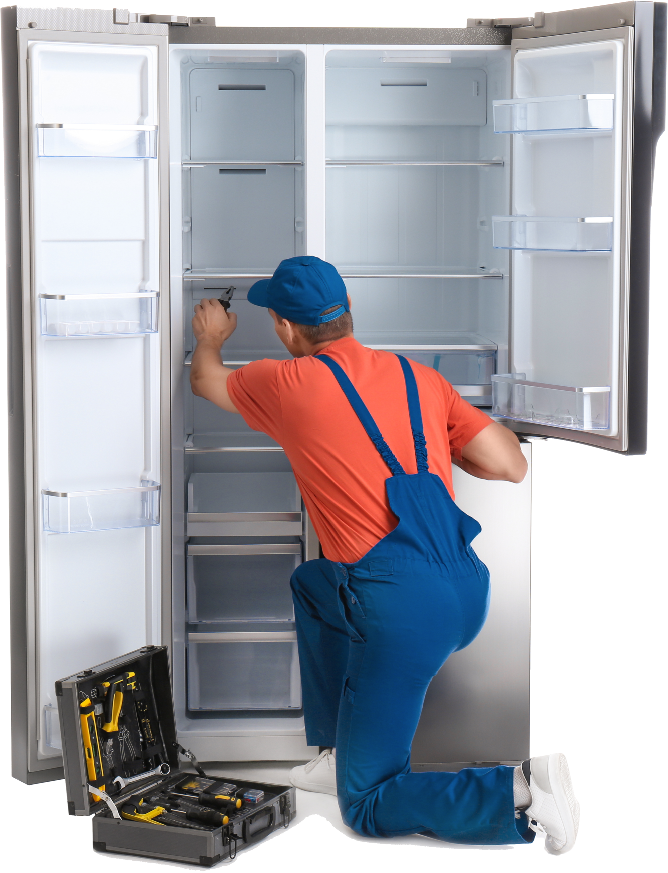 a man is kneeling down fixing a refrigerator .