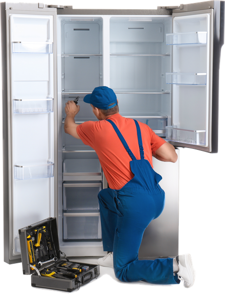 a man is kneeling down fixing a refrigerator .