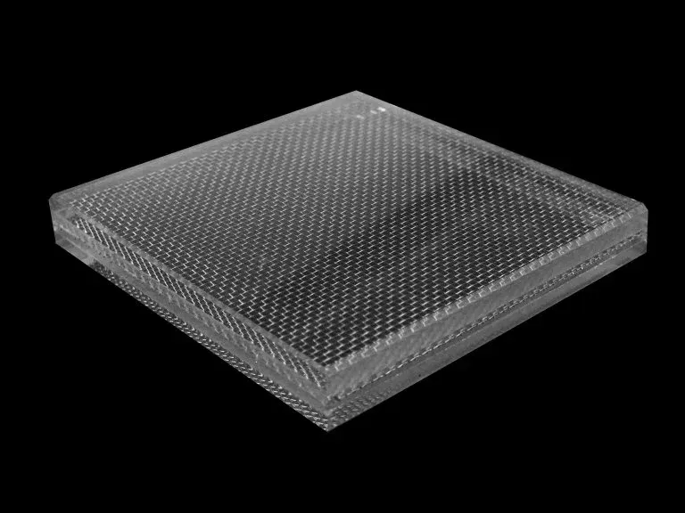 A clear plastic block with holes in it on a black background.