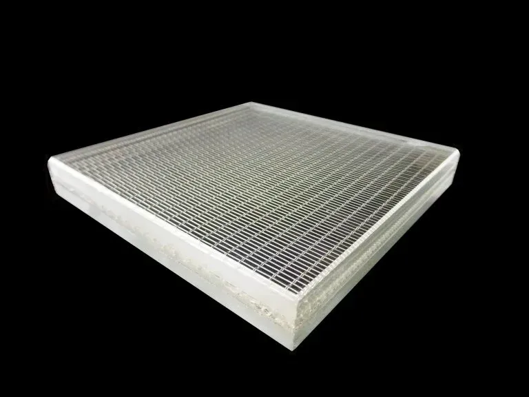 A square piece of metal with holes in it on a black background.