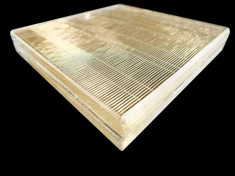 A square piece of glass with holes in it on a black background