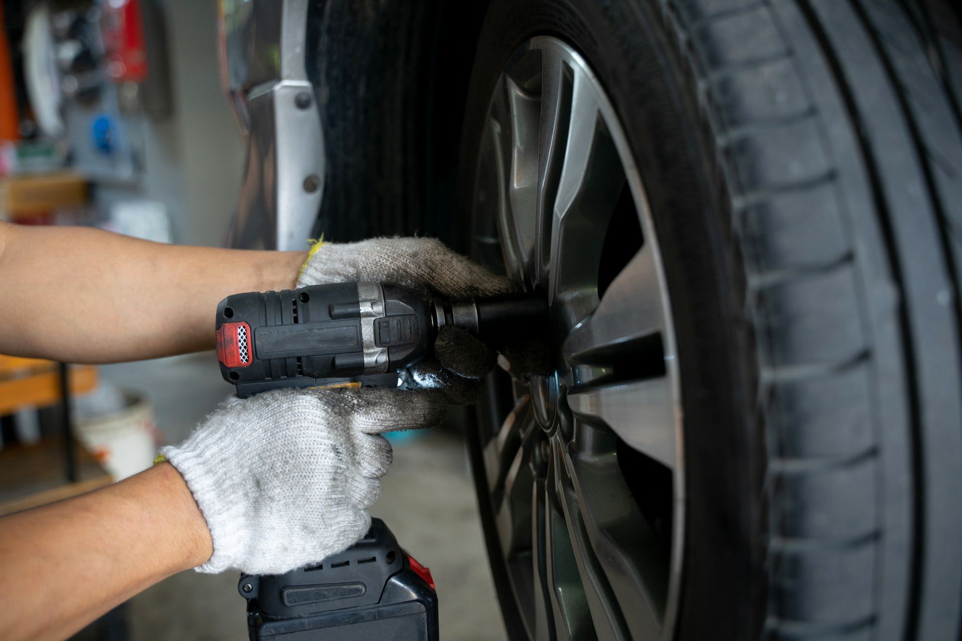 A Person Wearing White Gloves Is Working on A Car Wheel — Welshpool, WA — PTE Group Pty Ltd