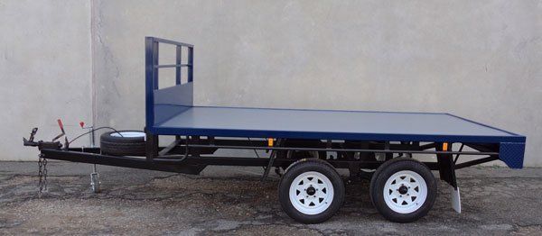A Blue Trailer with White Wheels Is Parked in Front of A White Wall — Welshpool, WA — PTE Group Pty Ltd
