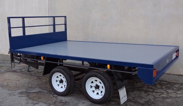 A Blue Trailer with White Wheels Is Parked in Front of A Building — Welshpool, WA — PTE Group Pty Ltd