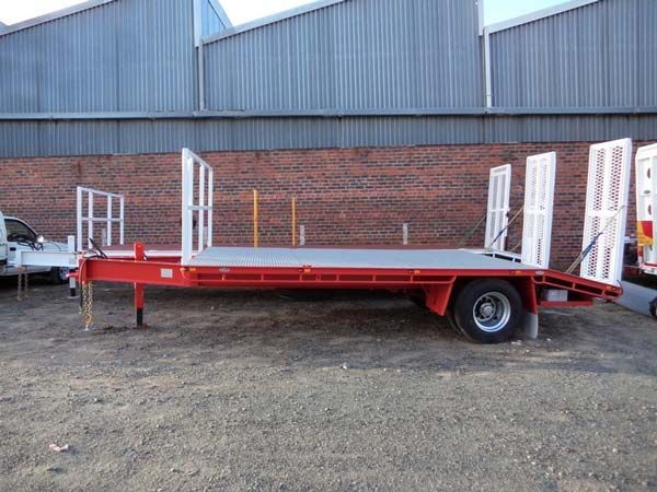 A Red and White Trailer Is Parked in Front of A Brick Building — Welshpool, WA — PTE Group Pty Ltd