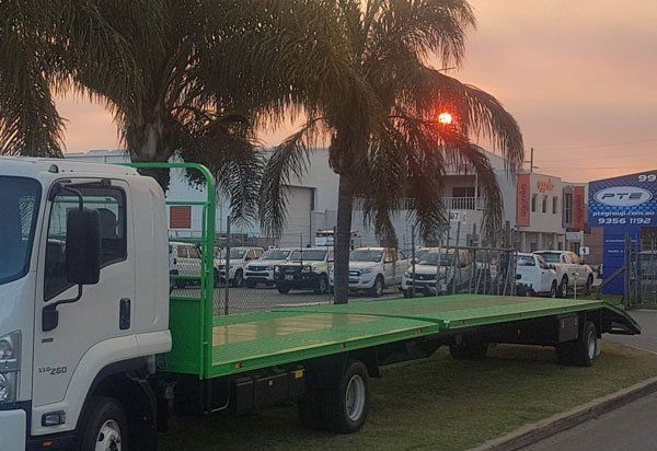 A White Truck with A Green Flatbed Trailer Is Parked on The Side of The Road — Welshpool, WA — PTE Group Pty Ltd