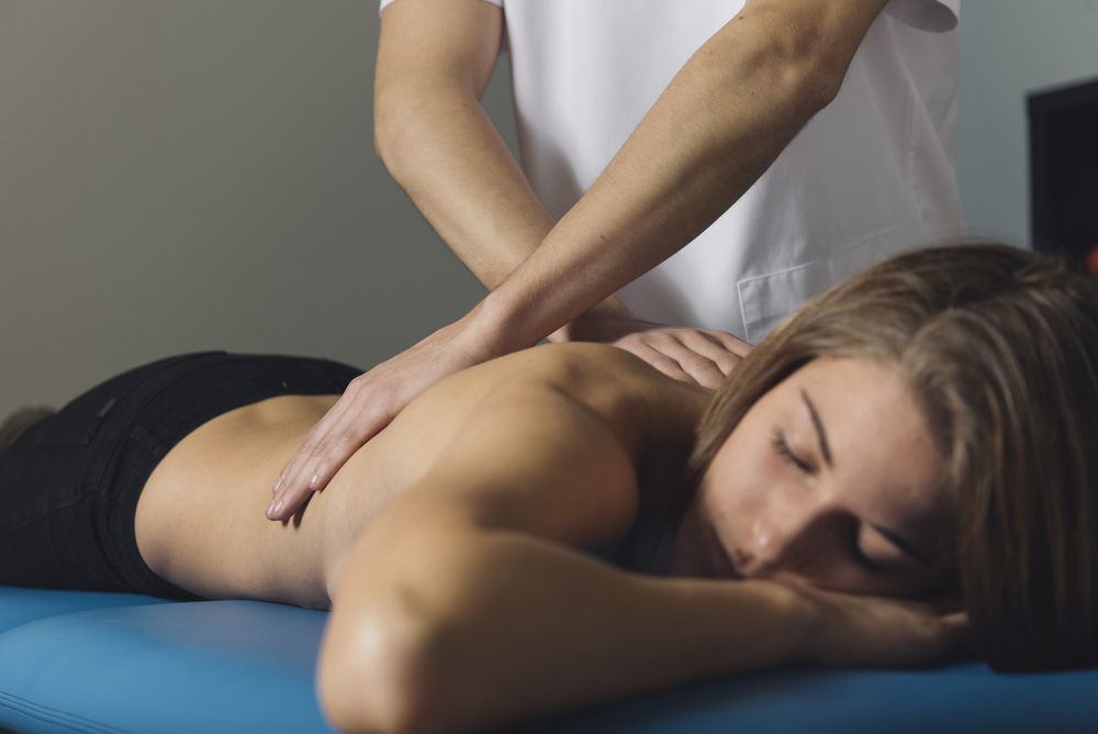 A Woman Is Laying On A Table Getting A Massage — Caves Coastal Physiotherapy in Caves Beach, NSW