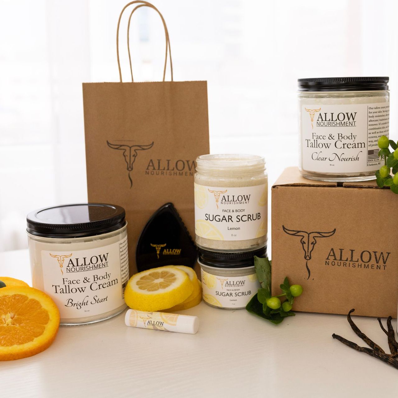 Several jars of allow nourishment tallow skincare products are on a table.