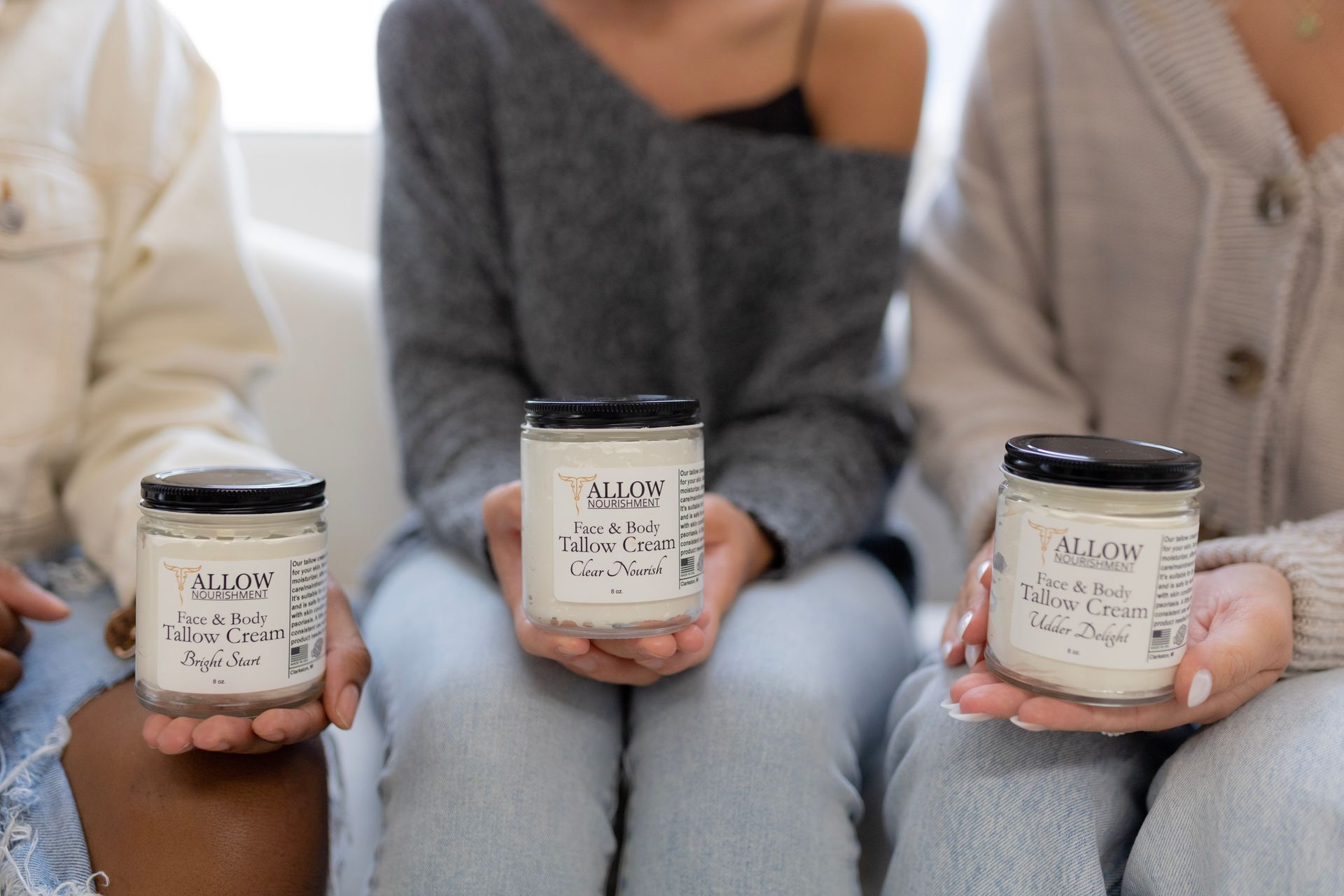Three ladies holding jars of tallow cream