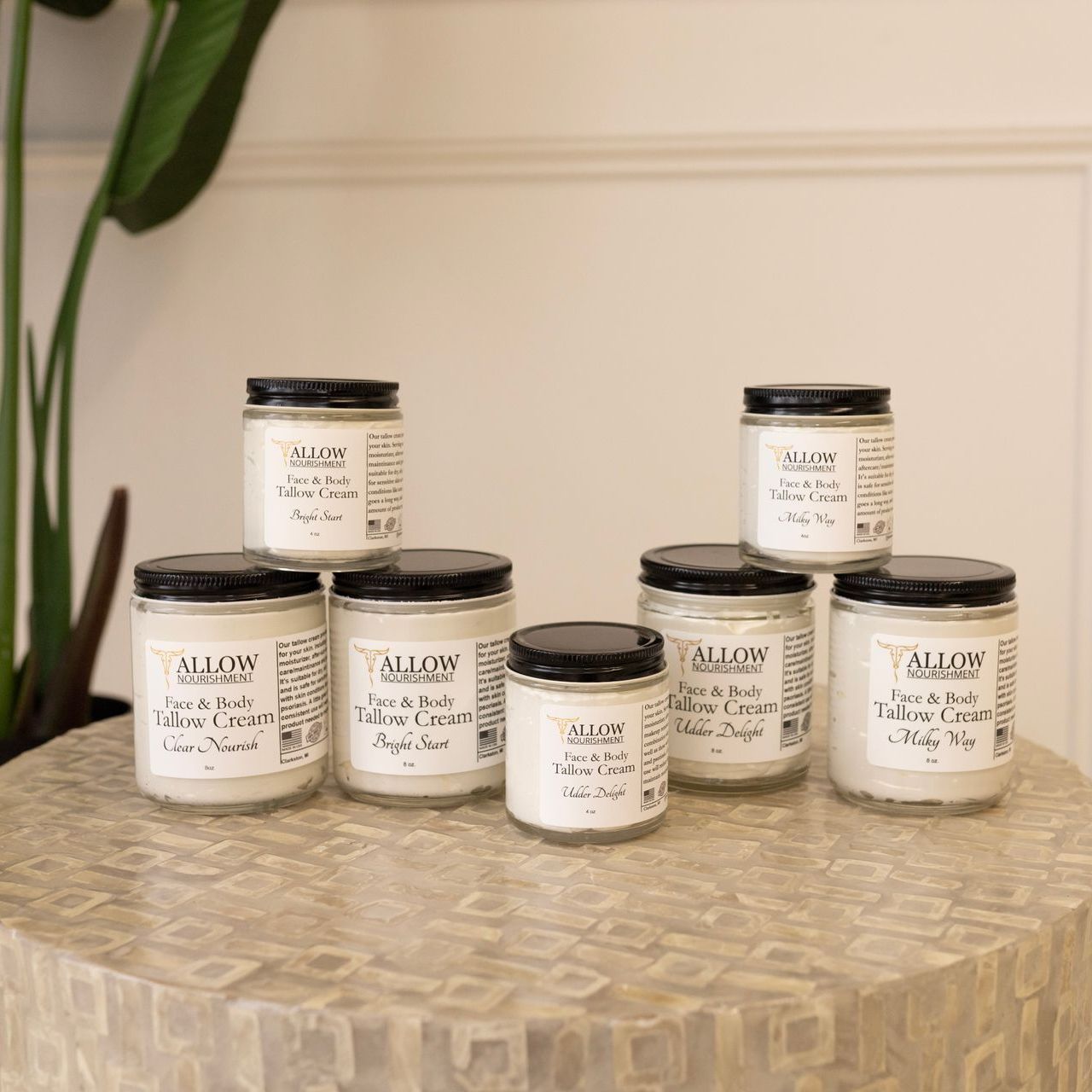 Allow Nourishment Tallow Face and Body Creams on a table. 