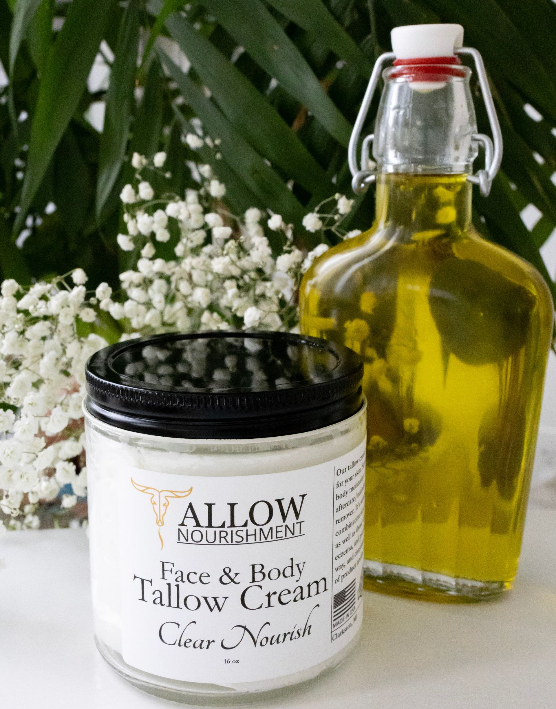 a jar of allow face and body tallow cream is next to a bottle of oil