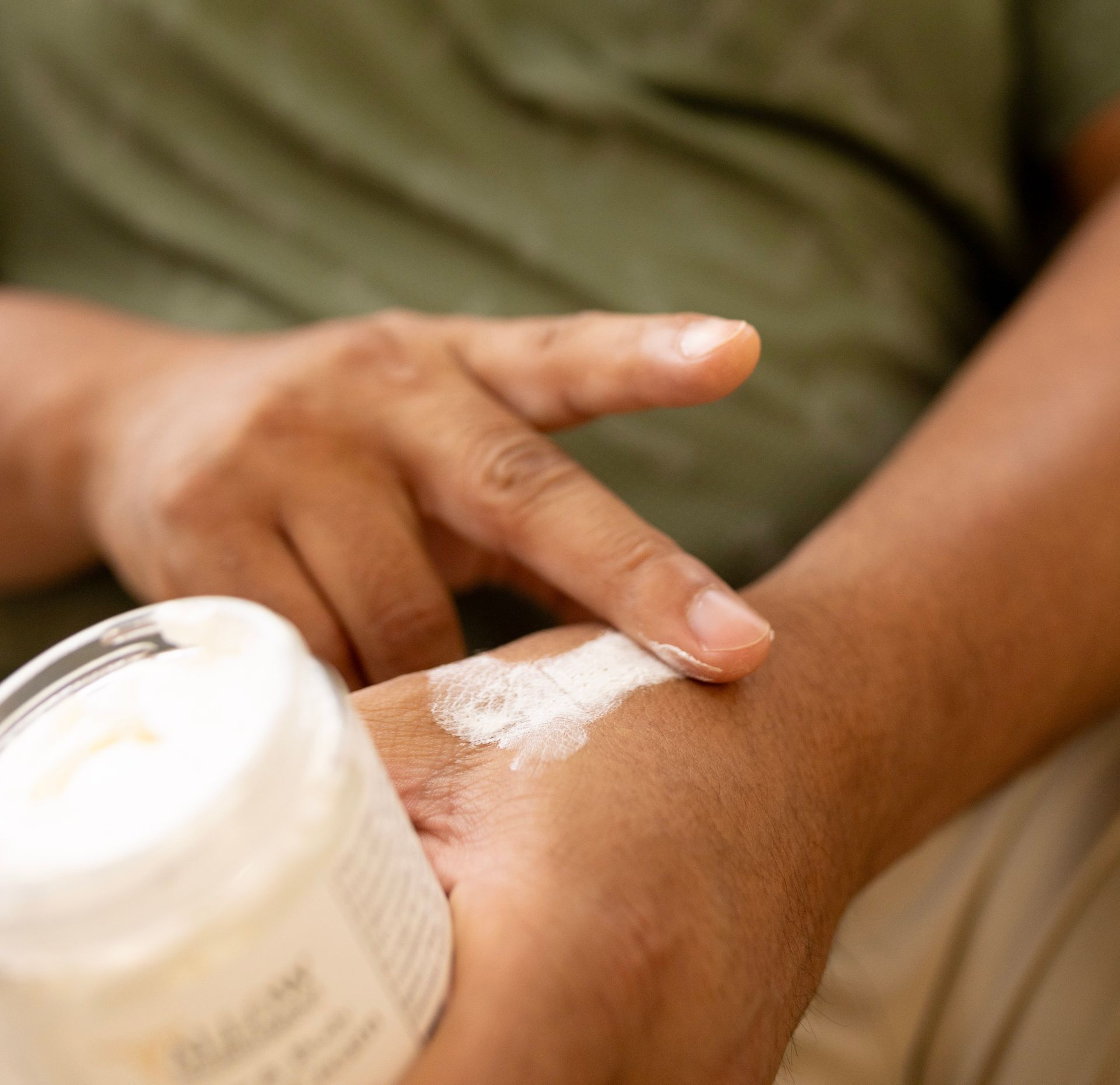 A person is applying Allow Nourishment Beef Tallow Face & Body Cream to their wrist.