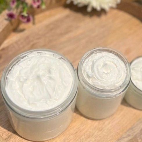 Three jars of Allow Nourishment Tallow Face and Body Cream are sitting on a wooden tray.