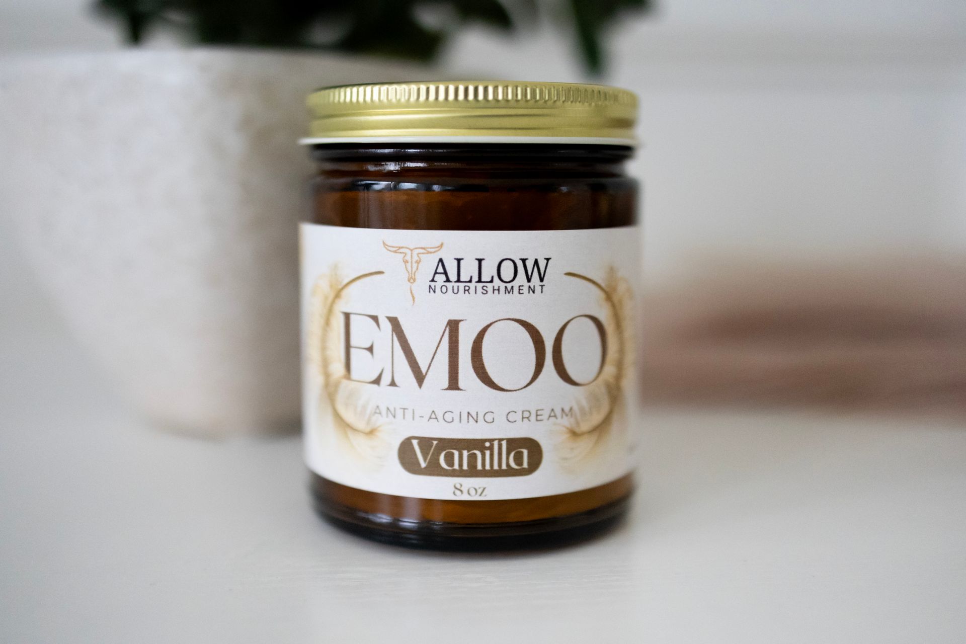 A jar of Allow Nourishments Emoo Anti-aging vanilla cream is sitting on a table.