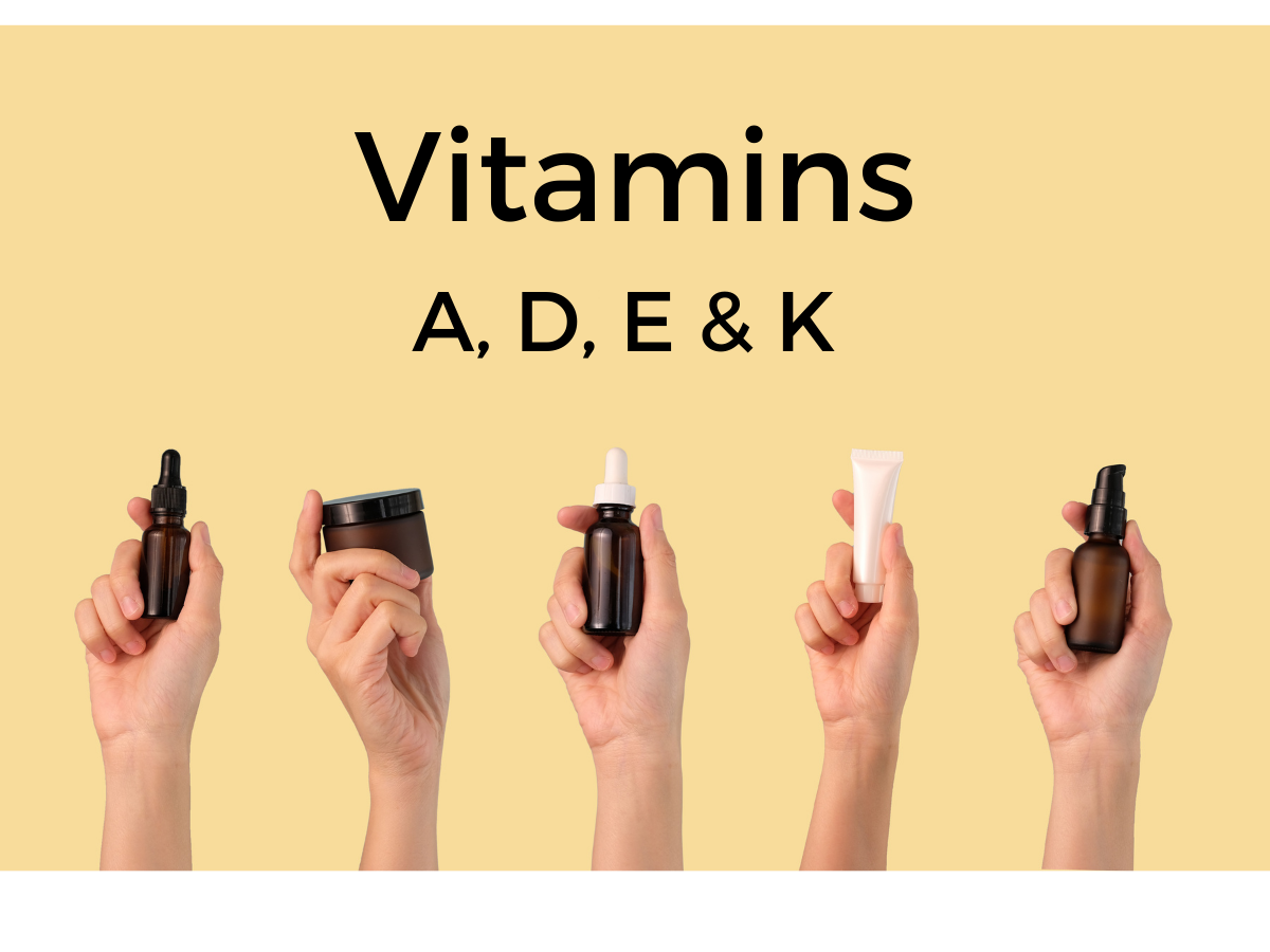 A picture of a hand holding different small bottles of vitamins A, D, E and K