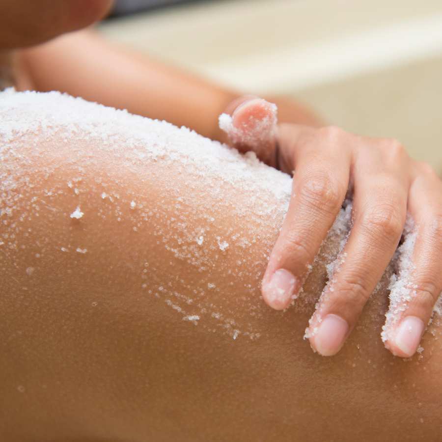 A person is scrubbing their skin with Allow Nourishment's Tallow Sugar Scrub. 