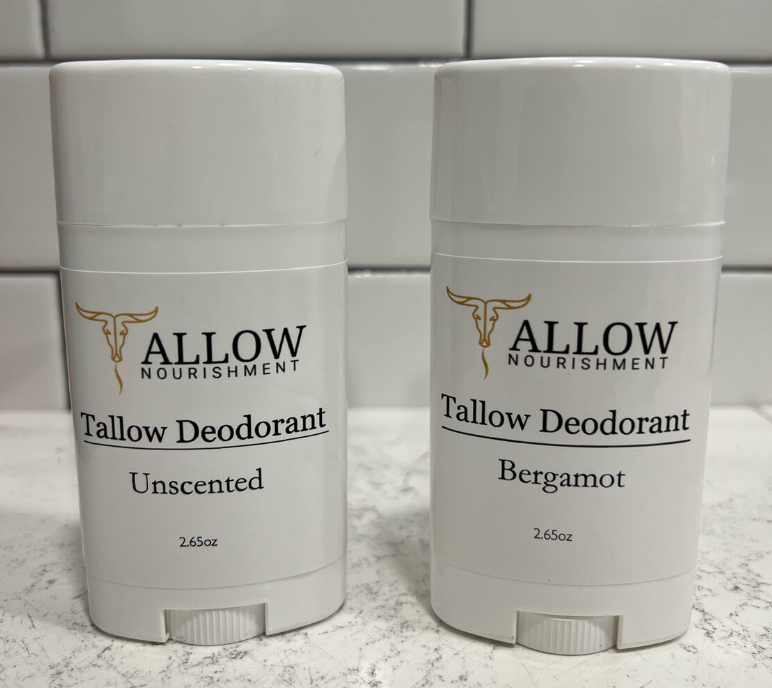 two bottles of tallow deodorant are sitting on a counter .