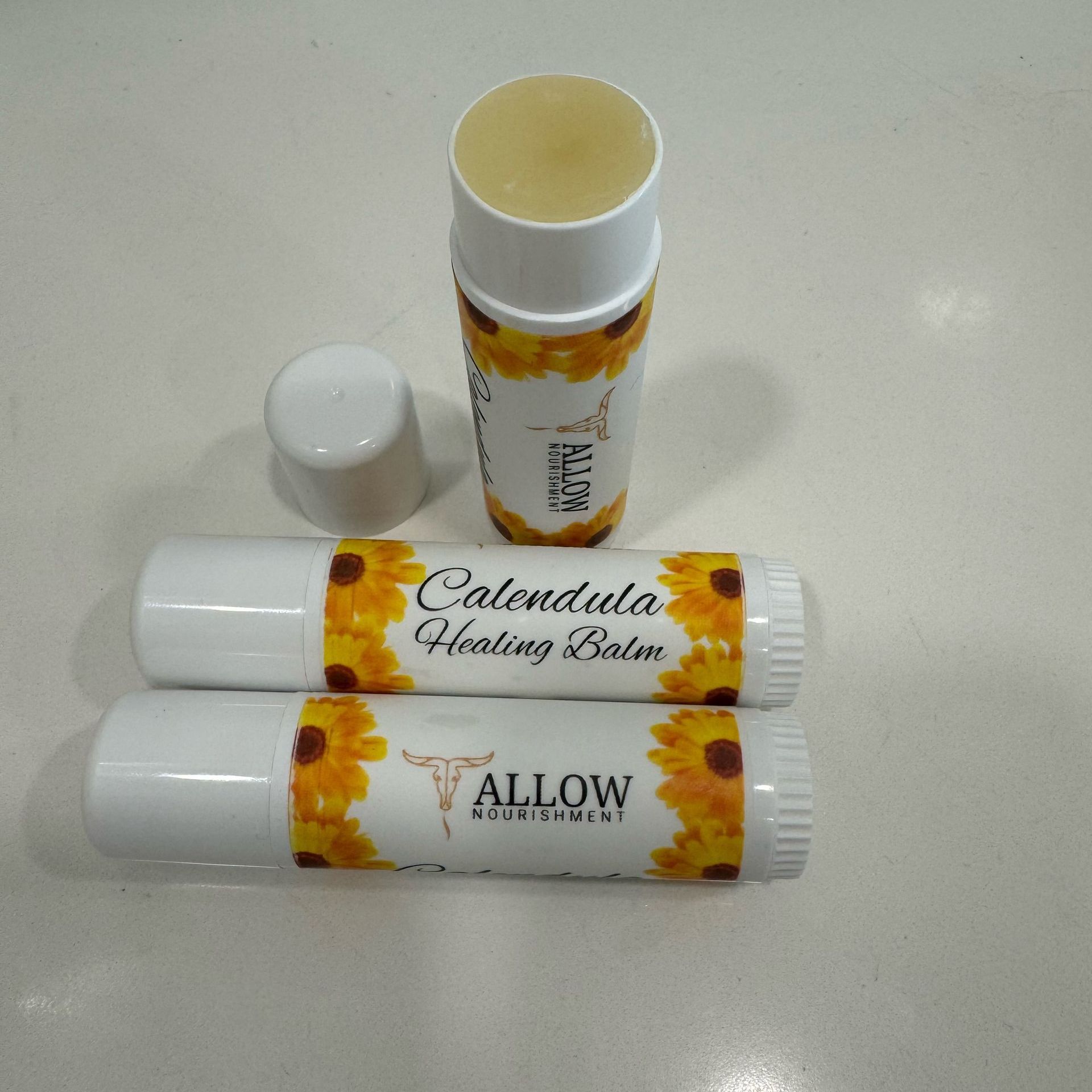 Two tubes of Allow Nourishment Tallow and calendula healing balm on a table