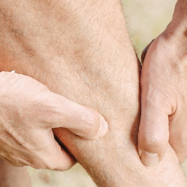 A man rubbing his leg muscles because he is sore.