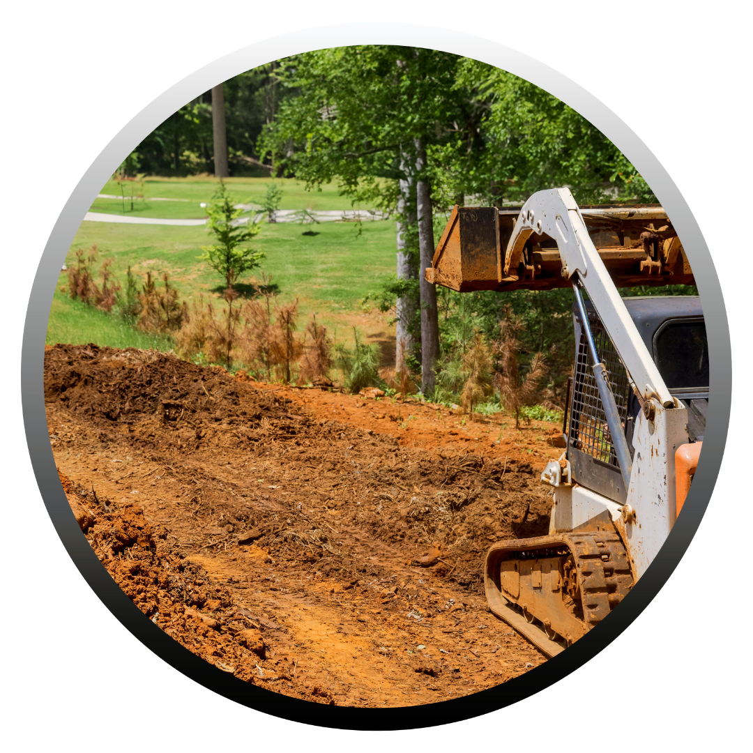 A skid-steer loader moving dirt on a grassy hillside, trees in the background.