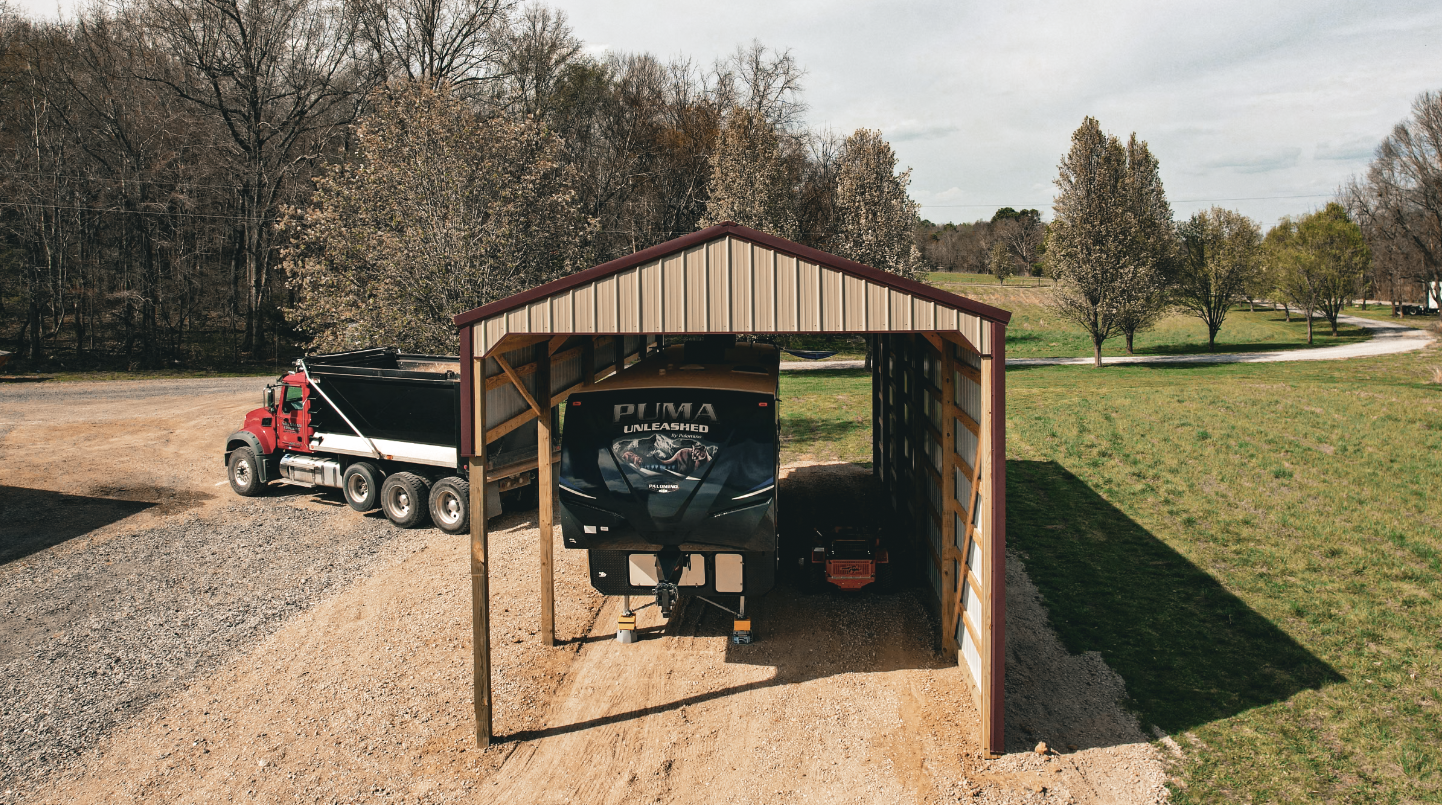 Tan metal garage with two garage doors, small side door, and a concrete driveway on a sunny day.