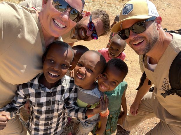 A group of people are posing for a picture with a group of children.